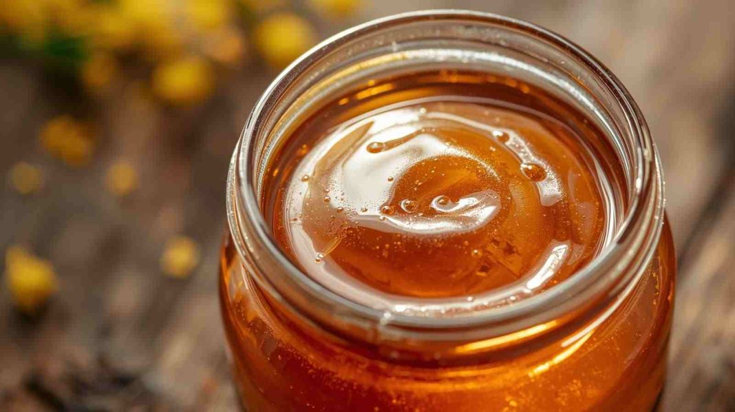কাঁচের বয়ামে রাখা সোনালী খাঁটি মধু।
